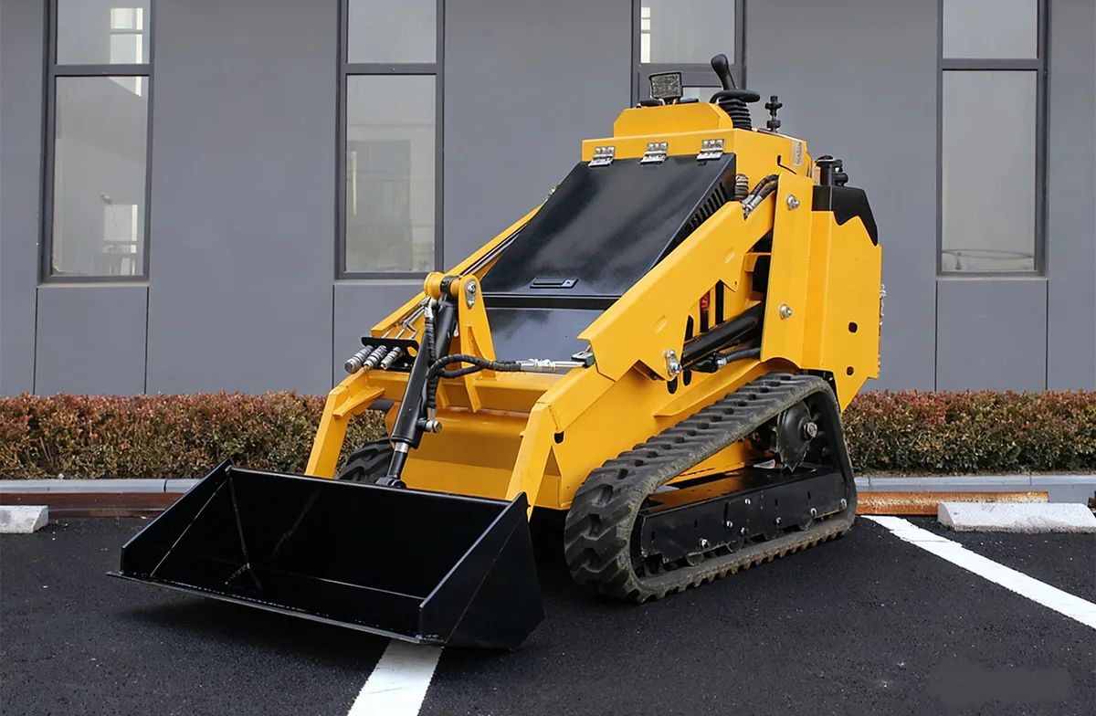 Yellow KORVA T750 tracked mini skid steer loader with bucket on firm ground